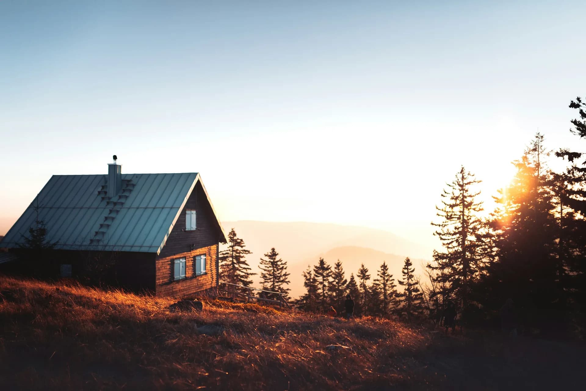 A Stormwright-built standing seam roof catching the last light over the ridge