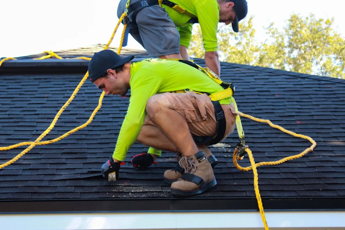 Stormwright crew installing architectural shingles on a steep roof