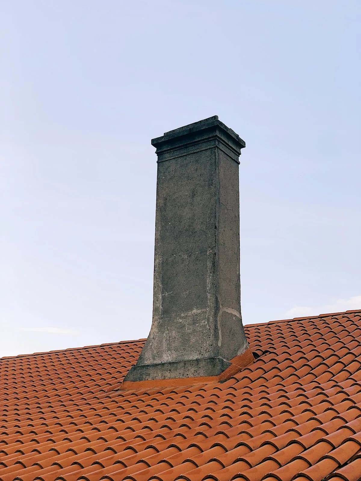 Rebuilt chimney crown on a terracotta roof