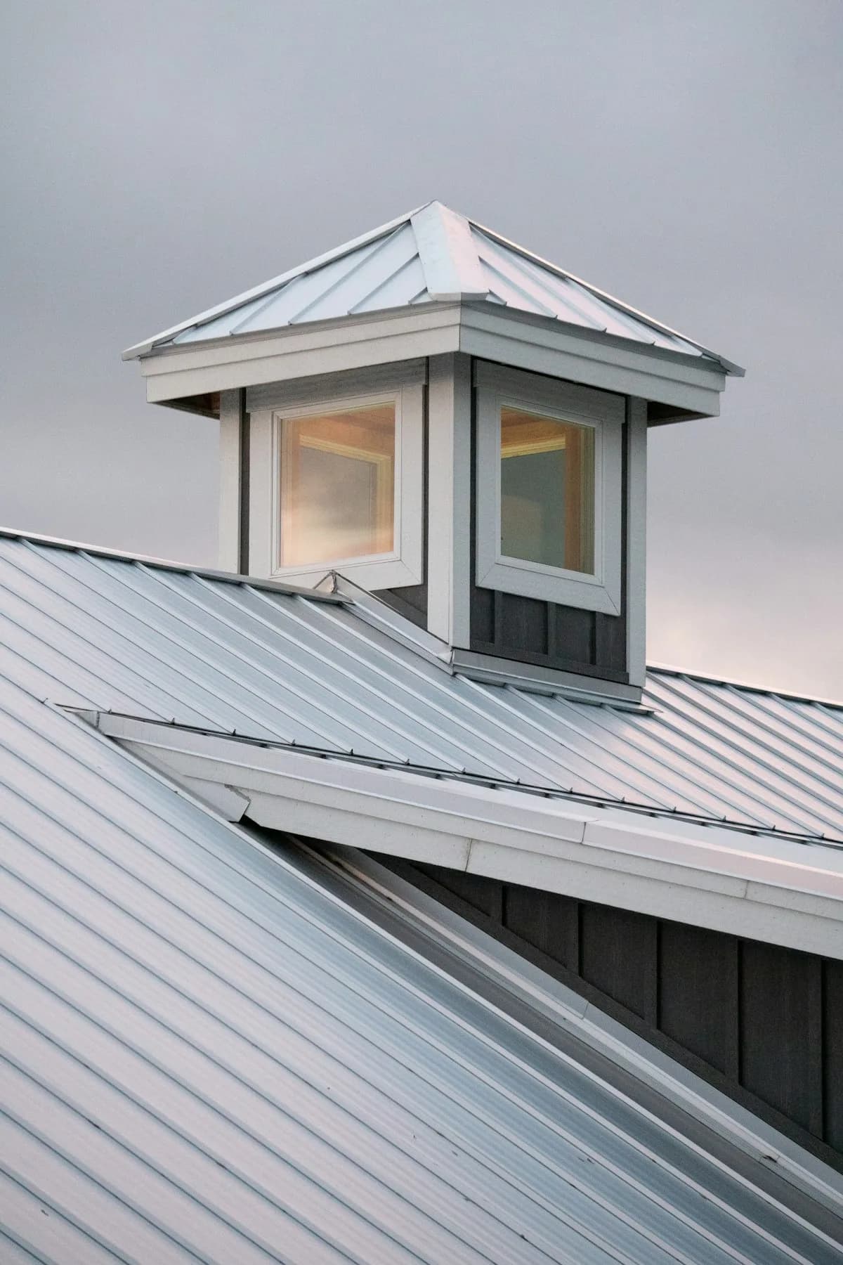 Silver standing seam roof with a windowed cupola